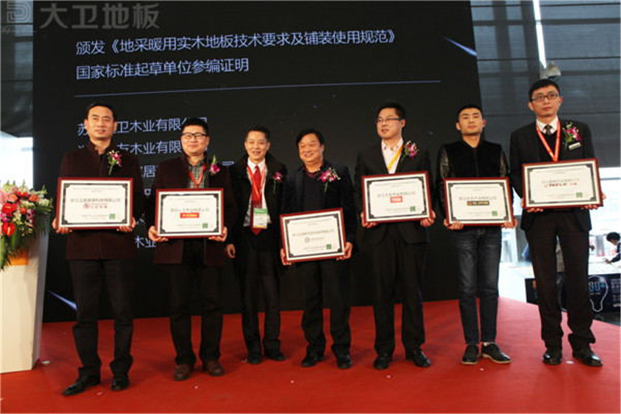 首页地板董事长蒋卫（左二）获颁《地采暖用ld官方网站技术要求及铺装使用规范》国家标准起草单位参编证明.jpg